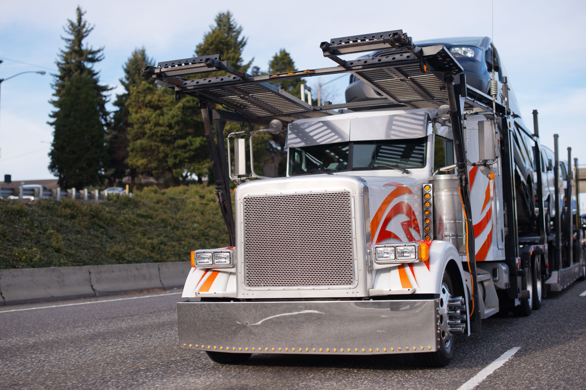 Classic big rig semi truck with car hauler semi trailer running on the road to loading cars for transporting to point of destination